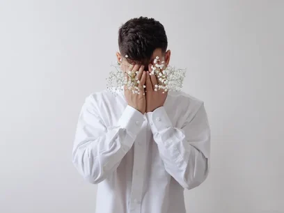 man covering her face with his hands